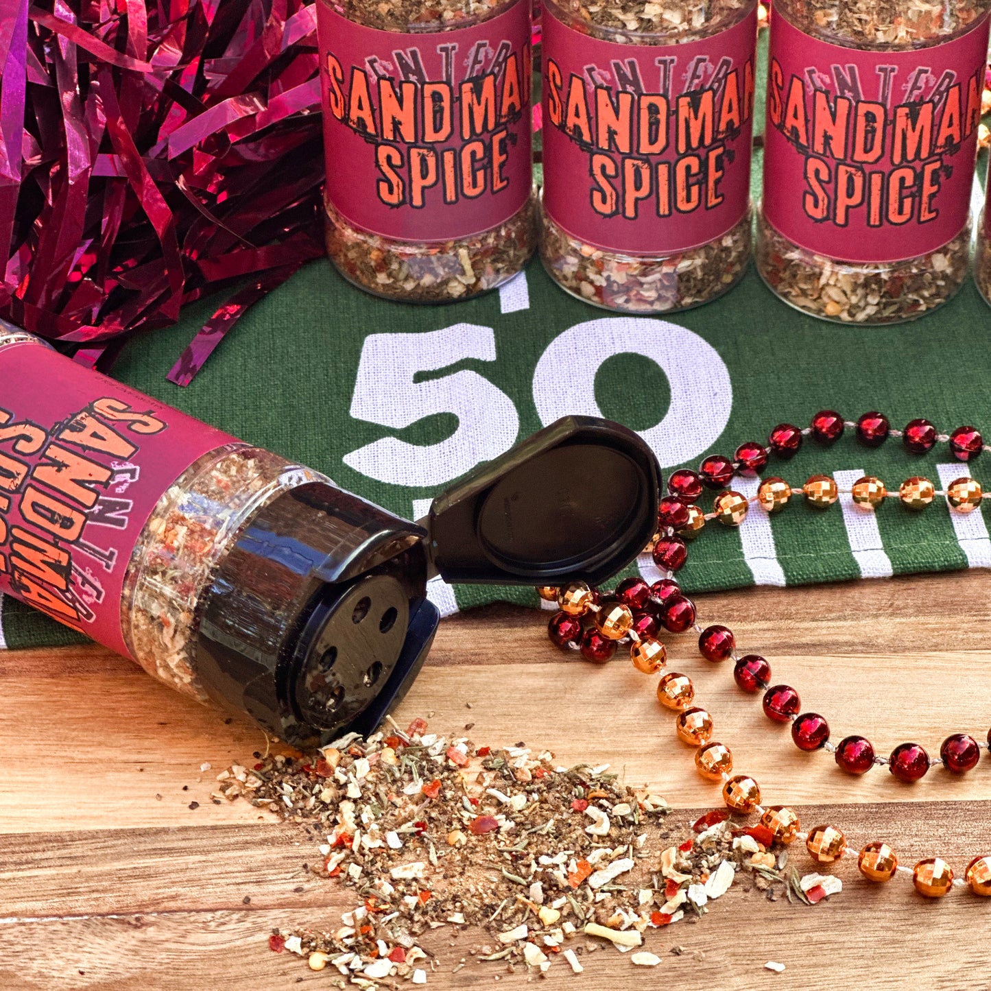 Gourmet tailgate spice mix for BBQ and grilling called "Sandman Spice" with maroon and orange label