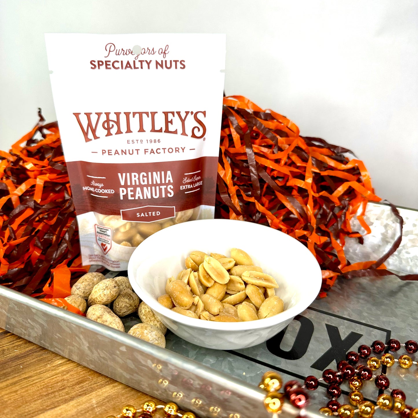 peanuts in a dish and a bag of specialty peanuts standing behind it
