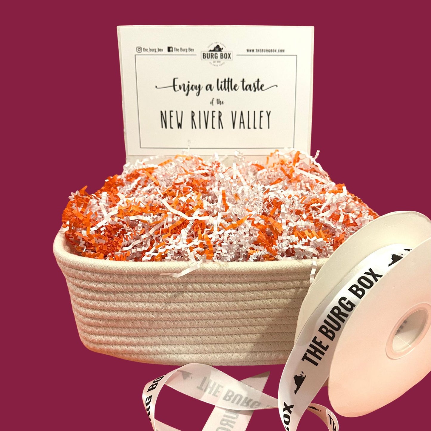 large woven cotton basket with ribbon and maroon background