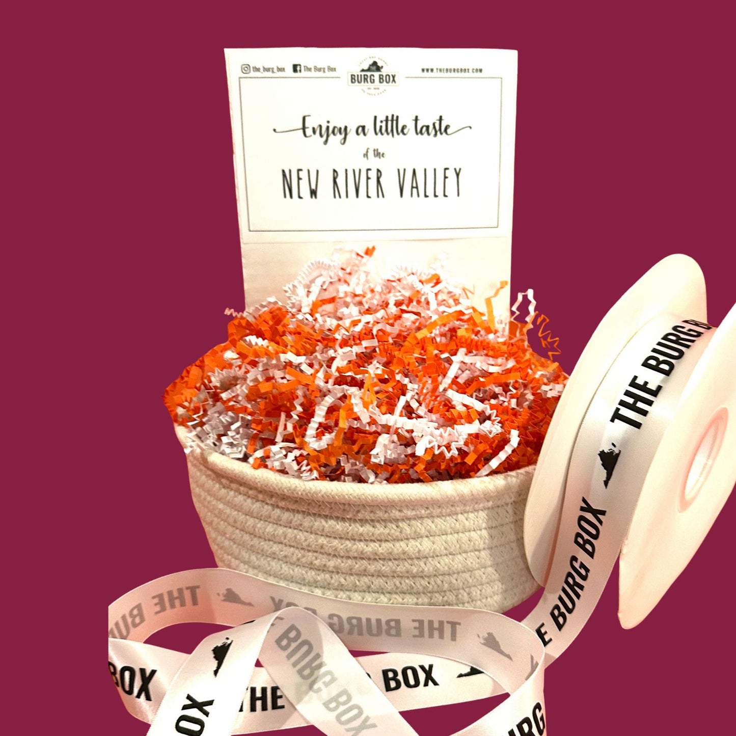 small woven cotton basket with ribbon and maroon background